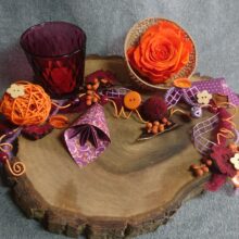 Wallnussbaumscheibe mit einer gefriergetrockneten Rose in einer Bell-cup Frucht. Dazu einTeelichtglas und verschiedenen Beiwerk mit Paperdesign schön arrangiert.