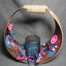 Kokosblatt gebunden, mit einem Teelichtglas und Beiwerk.